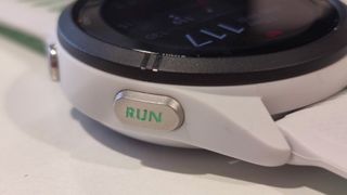 En vit Garmin Forerunner 265S med sin omdesignade knapp.