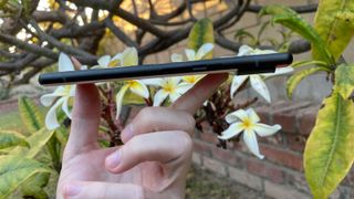 A Google Pixel 6 in someone's hand, viewed from the side