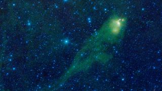 spacecraft photo of a large, green tadpole-shaped nebula in deep space, with lots of bright stars in the background