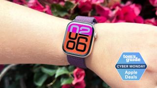 Person wearing the Apple Watch Series 10 in front of some flowers with the Tom's Guide Cyber Monday deals badge