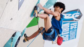 Sorato Anraku of Japan, in a blue vest and shorts, competes during the men's lead competition in the sports climbing at the 2024 Paris Olympic Games.