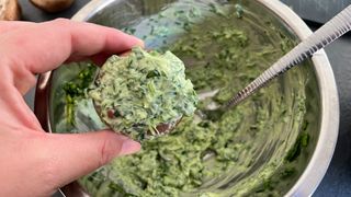 woman spooning stuffing into a mushroom