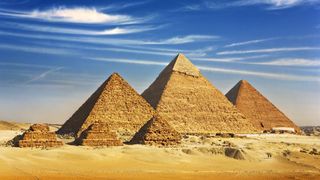 View from the Giza Plateau of the three pyramids known as Queens&#039; Pyramids with three smaller three satellite pyramids in front. In order from left to right: the Pyramid of Menkaure, Khafre and then Khufu.