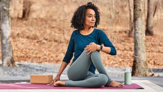 Woman doing yoga wearing Fitbit Charge 5