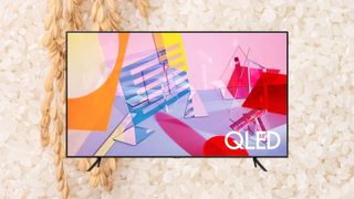 A Samsung QLED TV against a background of rice