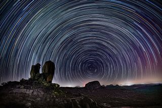 A long-exposure image shows stars appearing to whirl around Polaris, the north star, which appears fixed in the sky.