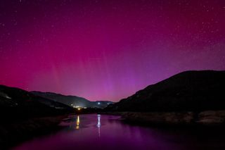 Pink and purple hues of the northern lights over Berga, Spain.