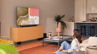 The Samsung Q60T in a living room on a wooden TV unit.