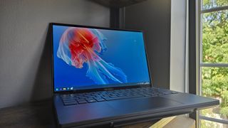 The Asus Zenbook Duo laptop photographed on a wooden desk.