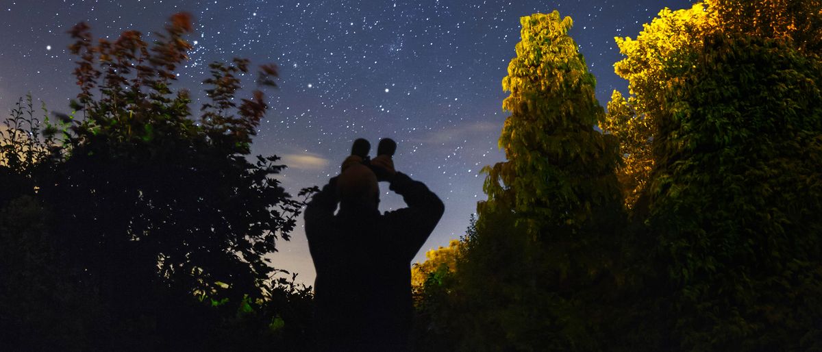 An amateur astronomer using binoculars to look at the stars