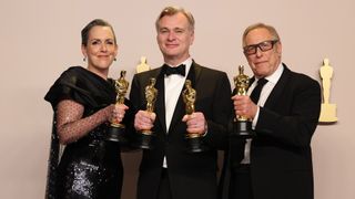 Emma Thomas, Christopher Nolan, and Charles Roven pose with four of Oppenheimer&#039;s seven Oscar trophies during an official photoshoot