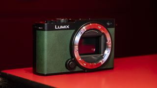 Panasonic Lumix S9 camera in Dark Olive color on a rich red reflective surface