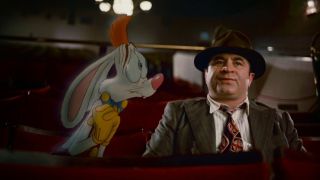 Bob Hoskins as Eddie Valiant sitting in a cinema with Roger Rabbit during the movie Who Framed Roger Rabbit?