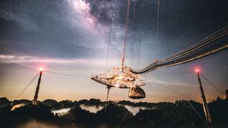 a starry sky over a radio dish suspended by towers