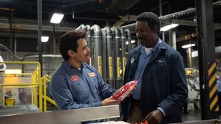 Two men hold a packet of Cheetos in Flamin Hot