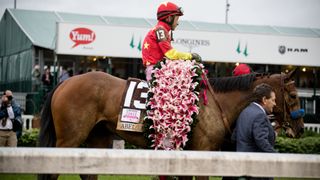 The winner of the Kentucky Oaks is handed the famous garland of lilies