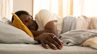 Man sleeping in bed wearing the Oura Ring