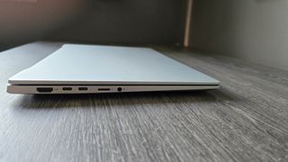 De Asus Vivobook S 15 Copilot+ in zilver op een houten bureau.