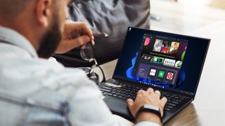 Een man die een laptop gebruikt met Windows 11's Microsoft Store open