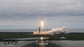 a black-and-white spacex falcon 9 rocket launches into a cloudy sky.