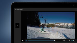 A laptop on a blue background showing the GoPro Quik app