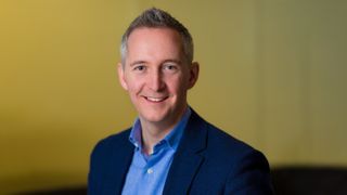 A photo of a Matt Harris, a man in a suit smiling at the camera