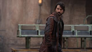 Cassian Andor looks behind him as he walks through Ferrix&#039;s main city in Andor on Disney Plus