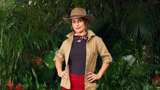 Coleen Rooney dressed in khakis and posing in front of some leaves ahead of her appearance in I'm a Celebrity 2024.