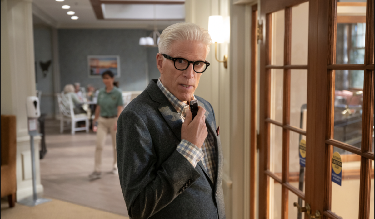 Ted Danson stands in a corridor holding a dictaphone up to his mouth