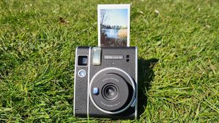 Fujifilm Instax Mini 40 sitting on a grass lawn