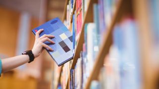 Kid reaching for a book wearing a smartwatch