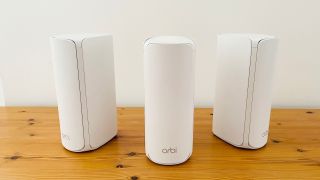 Netgear Orbi 770 router system side by side on a table