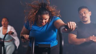 Woman doing metabolic conditioning workout on exercise bike