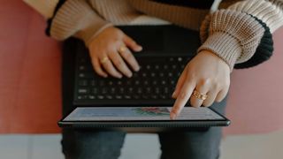 person typing and using touchscreen on laptop