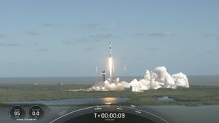 a black-and-white spacex falcon 9 rocket launches into a blue sky.