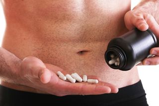 A man holds a bottle of creatine 