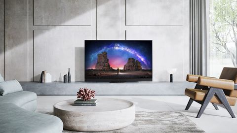 Panasonic JZ2000 OLED TV in white living room, with chair, sofa and coffee table