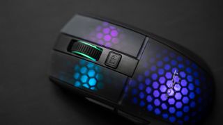 Roccat Burst Pro Air ligger mot en svart yta med RGB-belysningen aktiv.