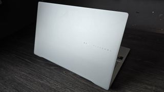 De Asus Vivobook S 15 Copilot+ in zilver op een houten bureau.