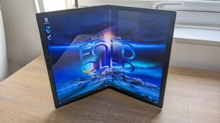 The Asus Zenbook 17 Fold OLED pictured on a wooden desk.