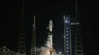 a black and white rocket ignites its engines on the launch pad at night, just as an abort is called. 