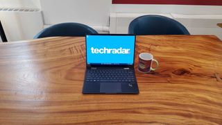 black laptop sitting on wooden desk