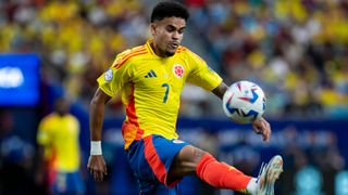 Luis Diaz controls the ball for Colombia in the yellow home shirt, blue shorts and red socks.