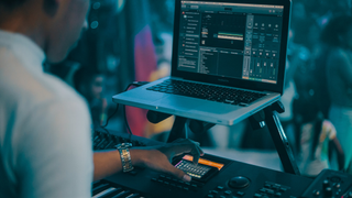 Man on keyboard using audio editor laptop