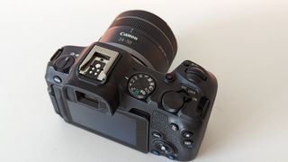 Canon EOS R8 set against a white backdrop with orange glow