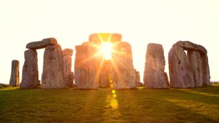 Sun shining through the stone arrangement at Stonehenge, U.K.