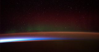 A photo of a rainbow-colored aurora over Antarctica