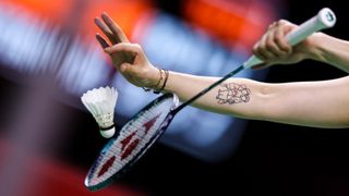 Close up of badminton racket and shuttlecock as player is about to serve