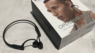 Best running headphones Shokz OpenRun Pro running headphones beside packaging