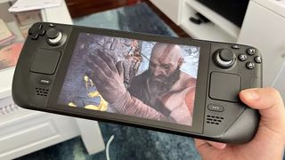 Valve's Steam Deck in a hand with God of War on the screen